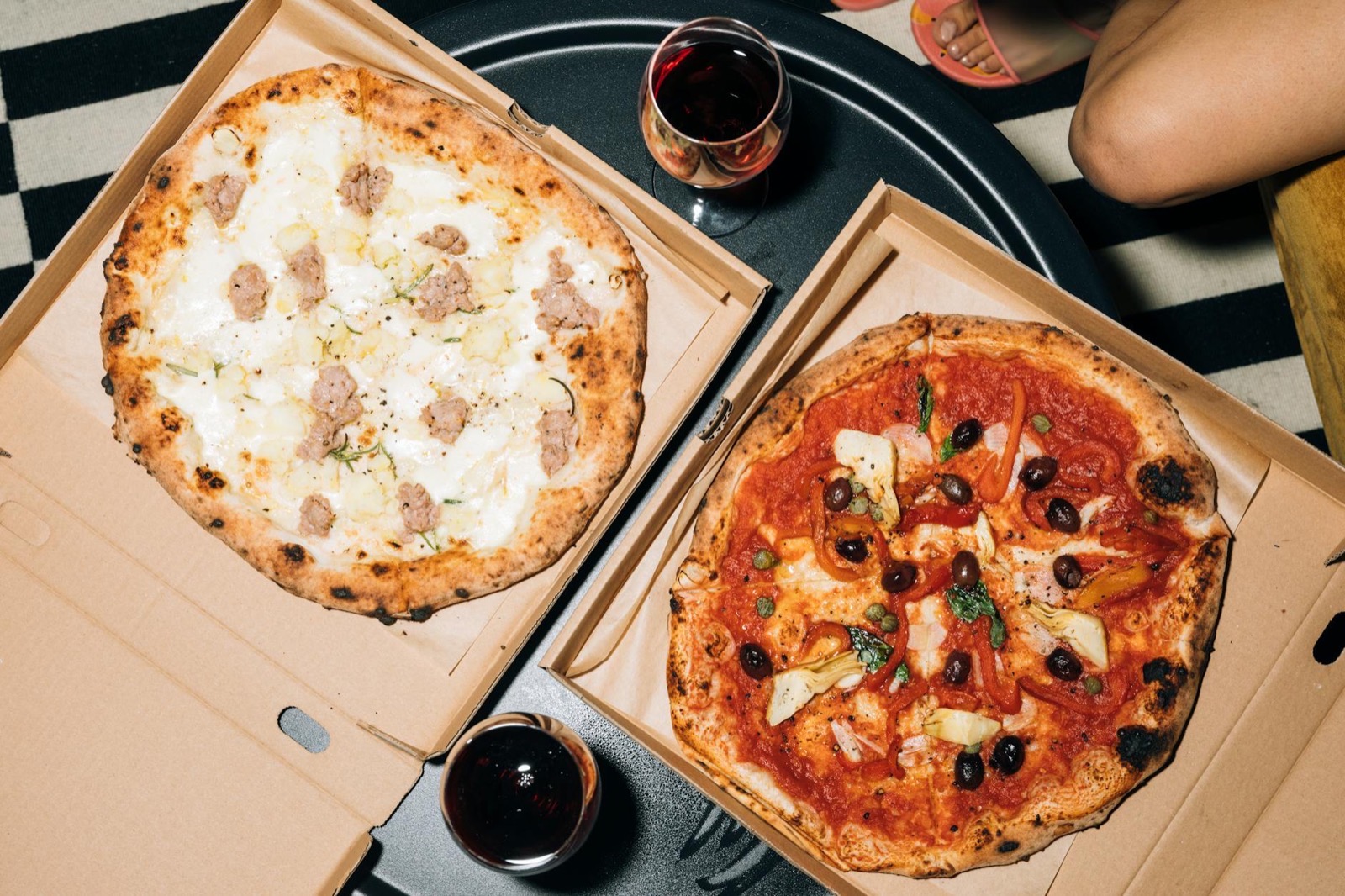 Dwie pizze w otwartych kartonach, widok z góry